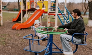 a woman and a baby playing in a park