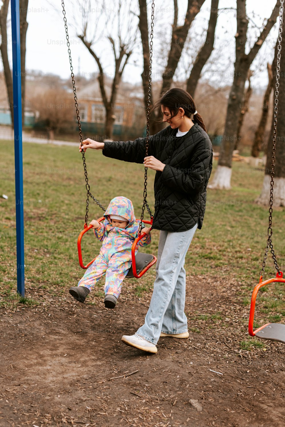 a man and a little girl playing on a swing set