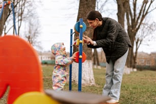 a woman playing with a child in a park