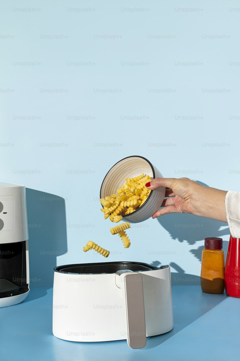 a person holding a bowl of food over a microwave