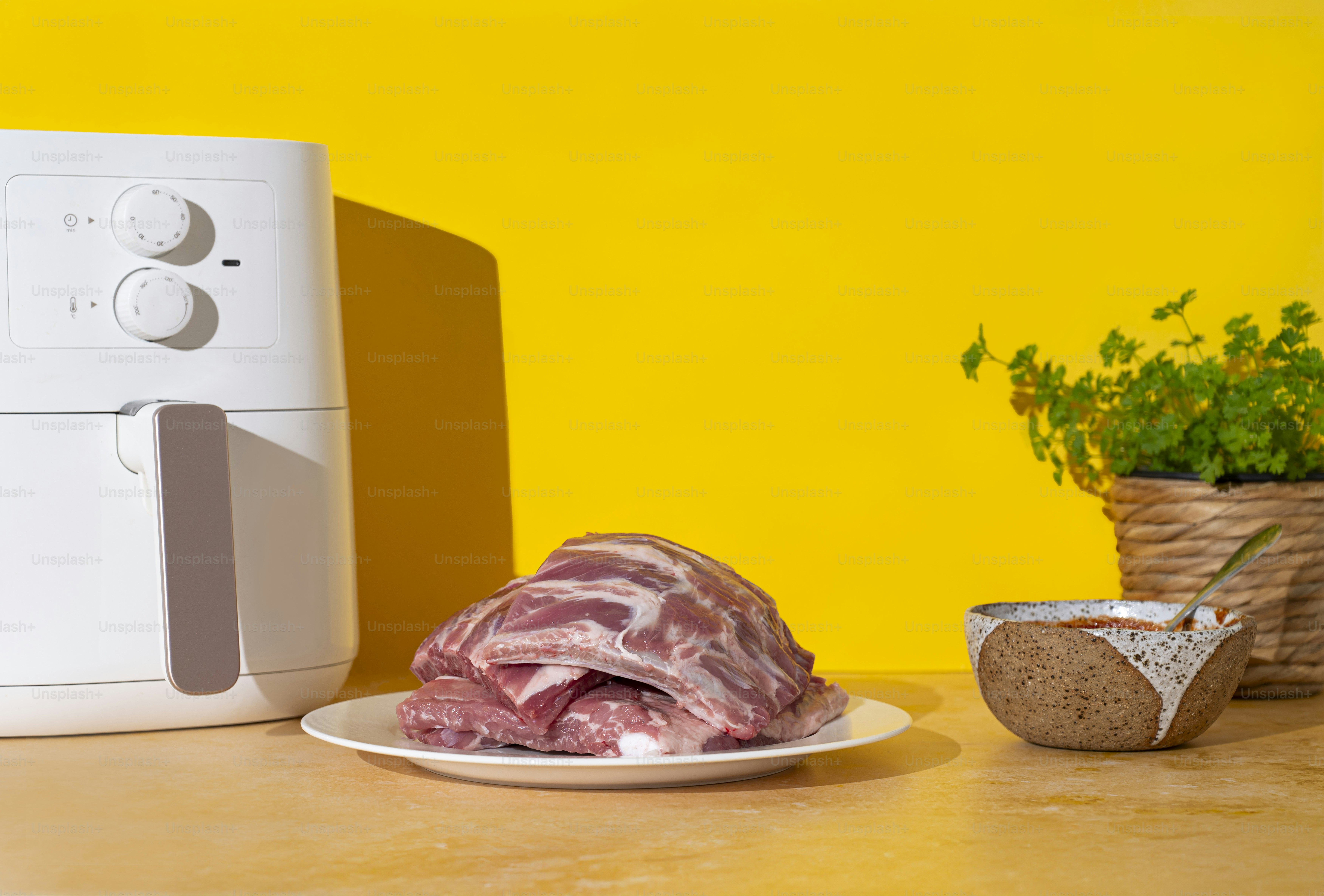 un morceau de viande posé sur une assiette à côté d’un micro-ondes