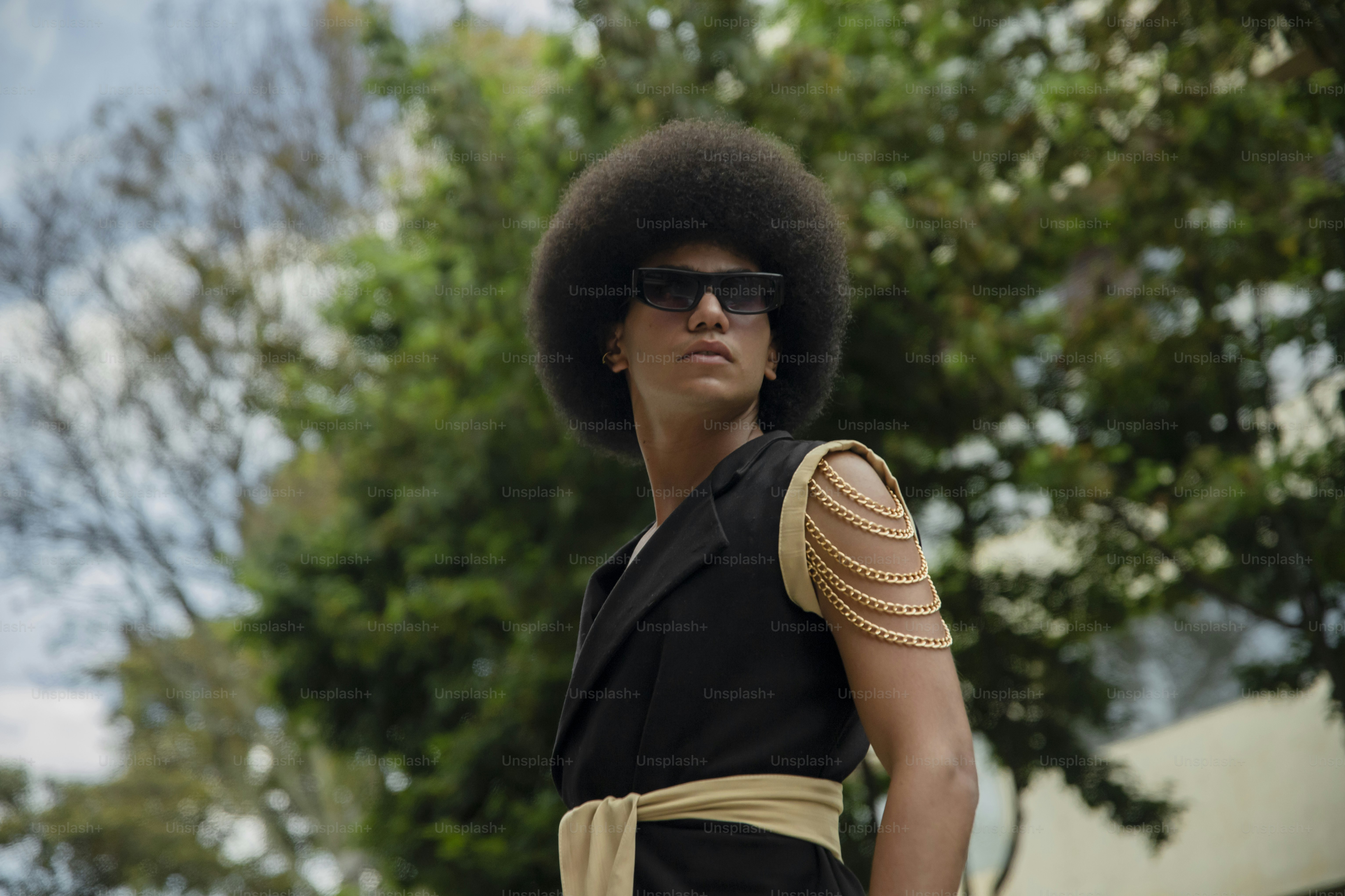 a woman with an afro wearing sunglasses and a dress