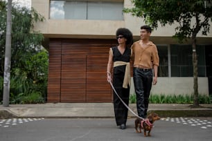 a man and woman walking a dog on a leash