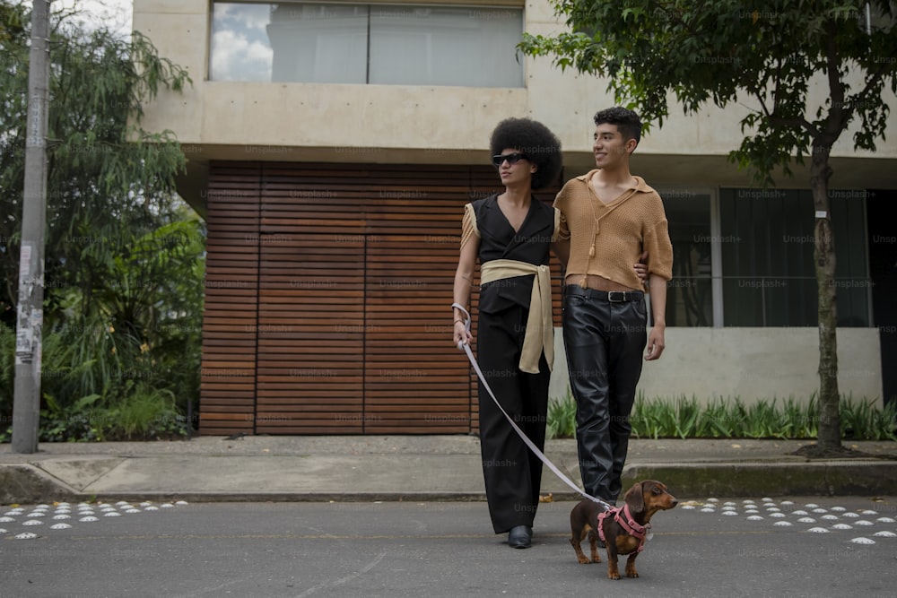 a man and woman walking a dog on a leash