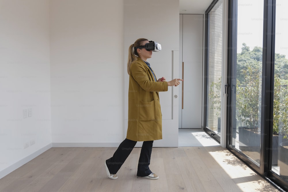 Una donna in un cappotto giallo sta usando un dispositivo di realtà virtuale