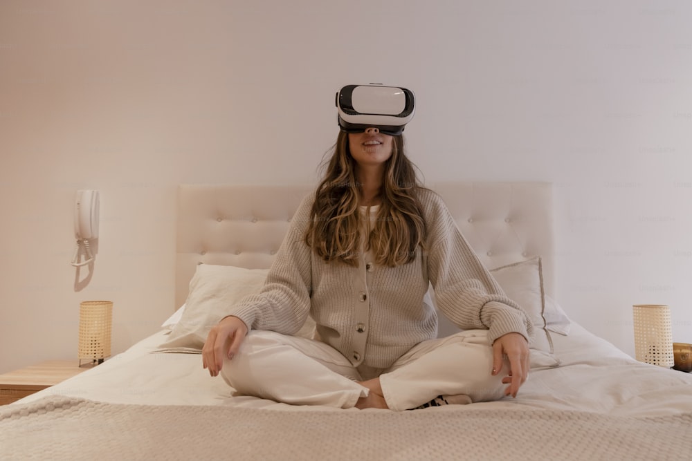 uma mulher sentada em uma cama usando um fone de ouvido virtual