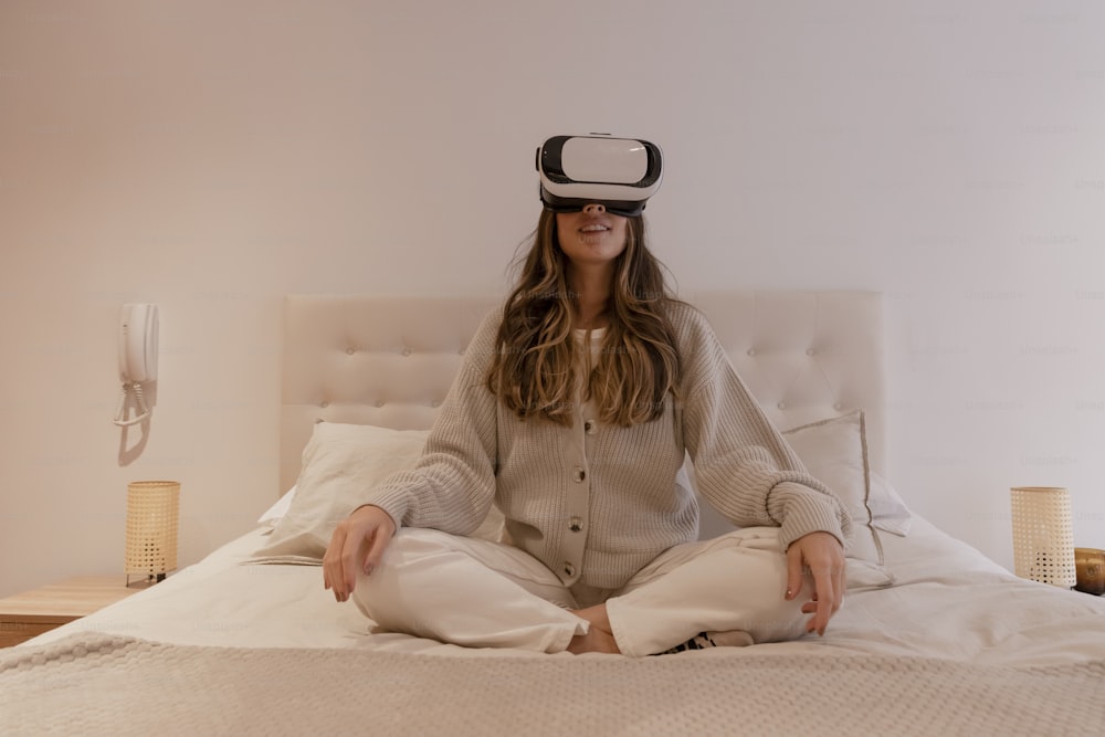 a woman sitting on a bed wearing a virtual headset