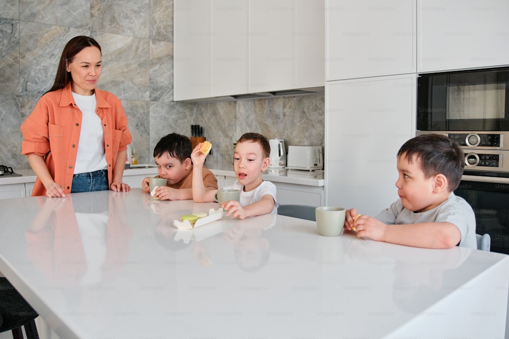 un groupe d’enfants assis autour d’une table de cuisine