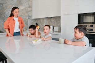 a group of children sitting around a kitchen table