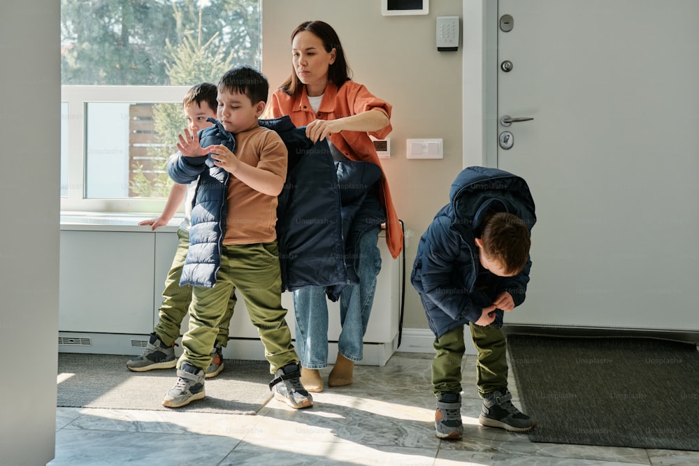 a group of children standing in front of a window