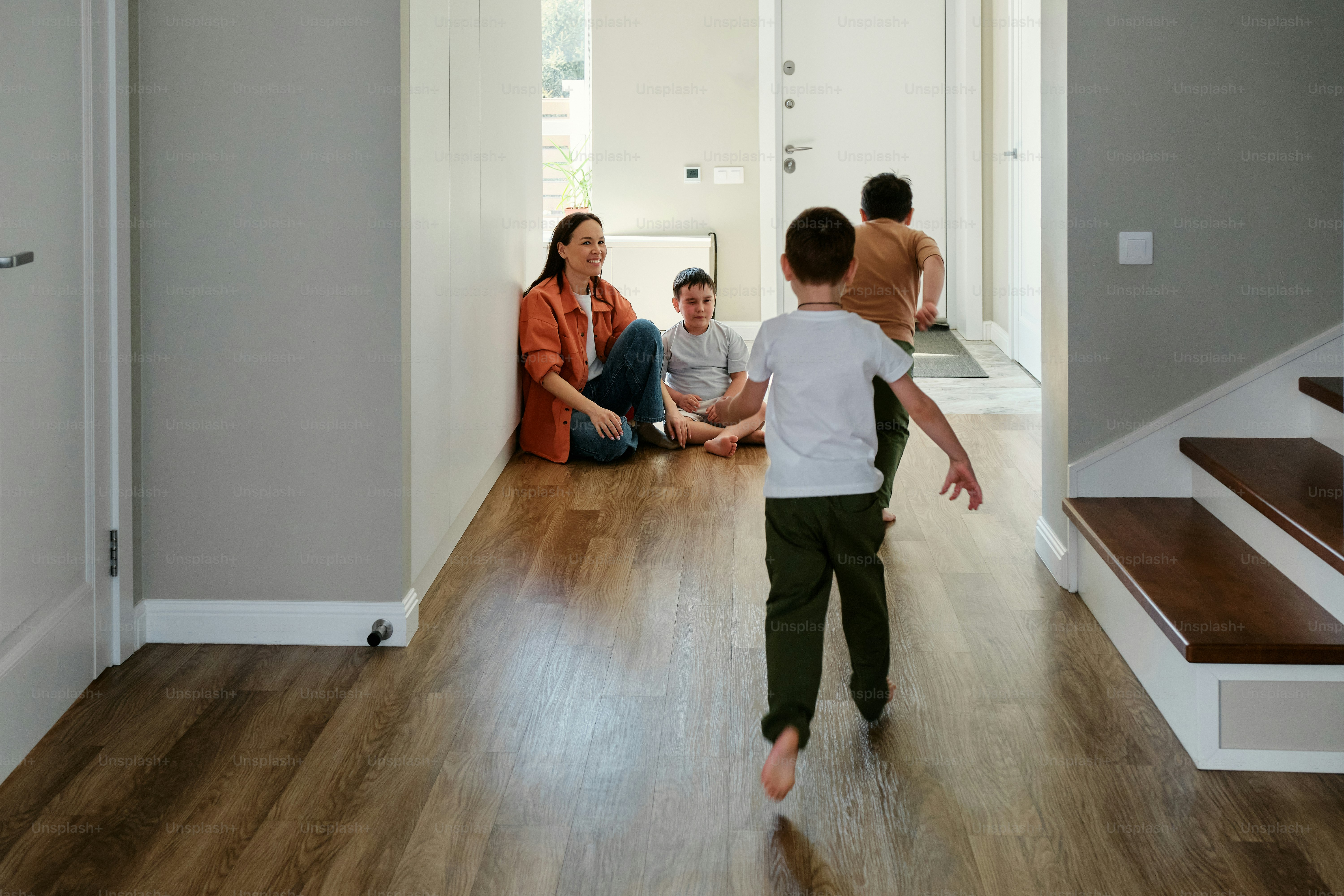 a young boy is playing with his family in the hallway