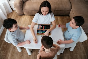 a woman sitting at a table with three children