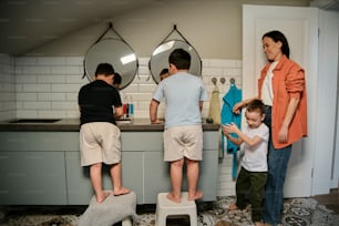 a group of children standing on stools in a bathroom