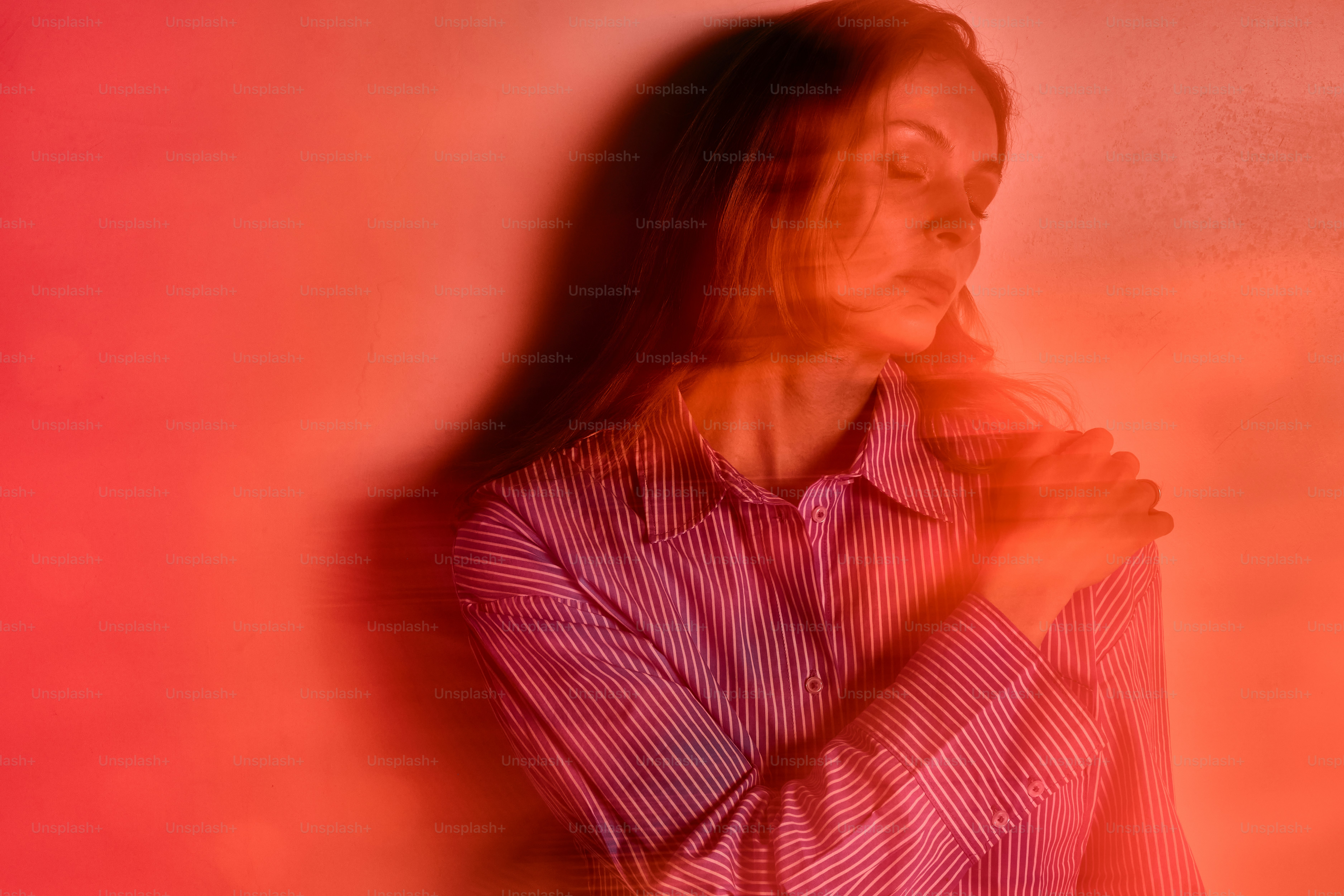 a woman standing in front of a red wall
