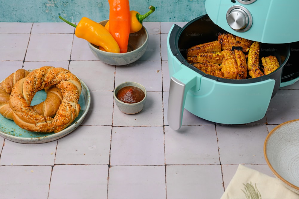 a table topped with a blue crock pot filled with food