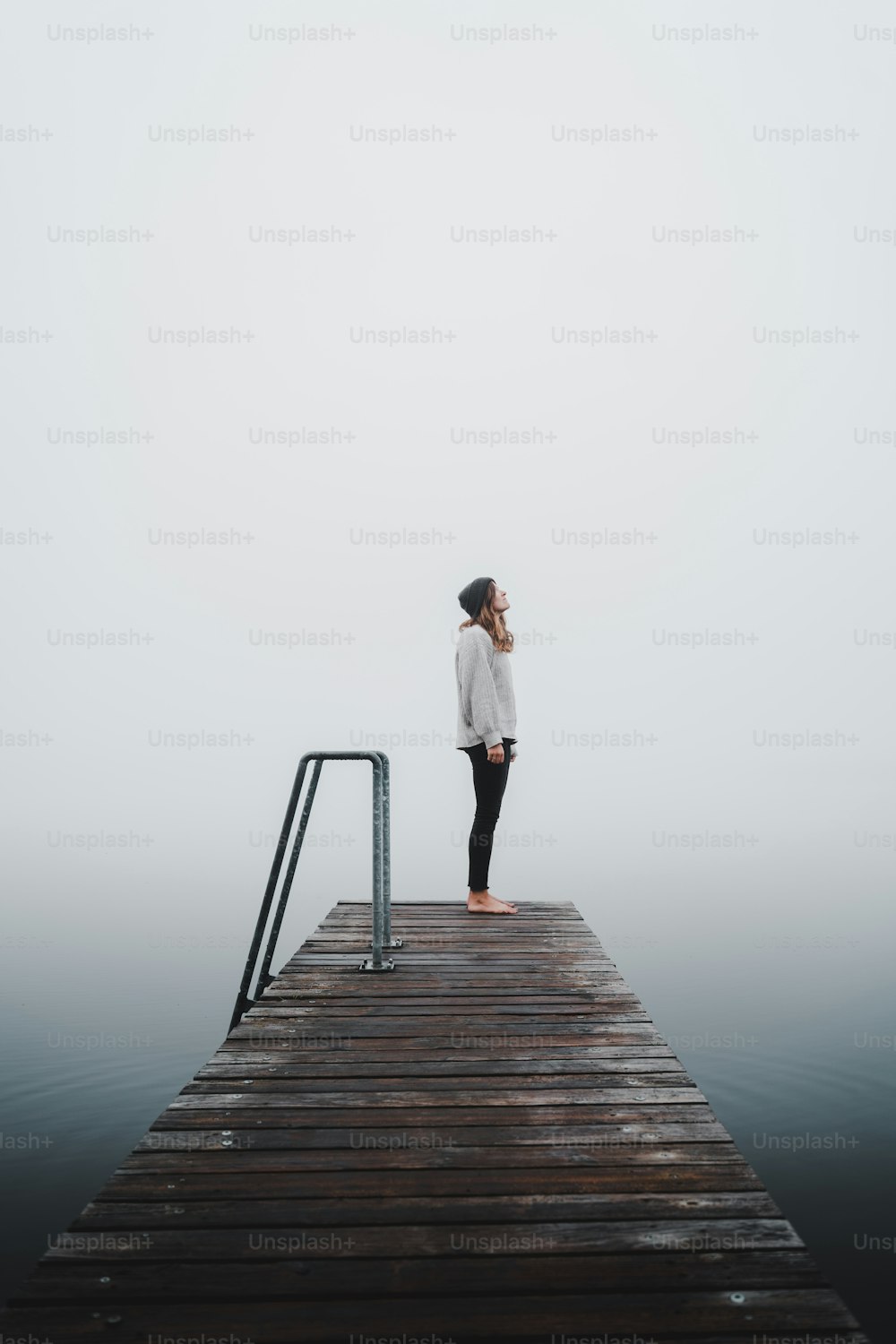 a person standing on a dock in the fog