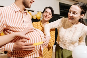 un groupe de personnes debout autour d’une femme enceinte