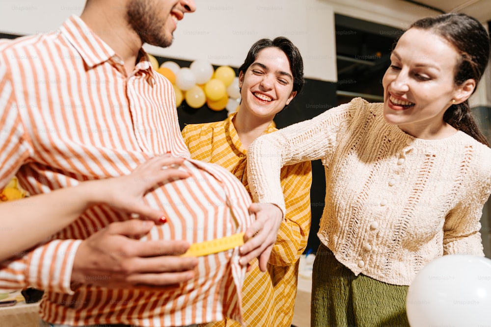 a group of people standing around a pregnant woman