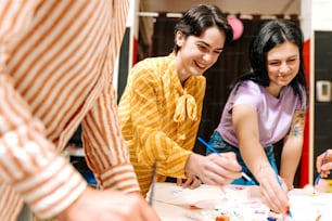 a group of people standing around a table cutting paper