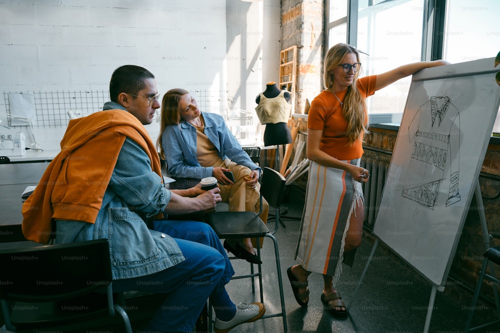 a group of people sitting around a white board