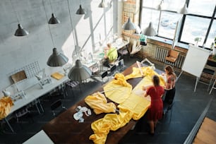 Eine Gruppe von Menschen, die um einen Tisch stehen, der mit gelbem Tuch bedeckt ist