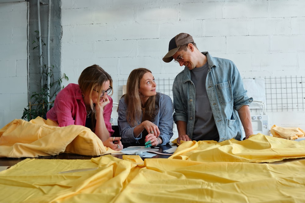 a group of people sitting around a yellow sheet