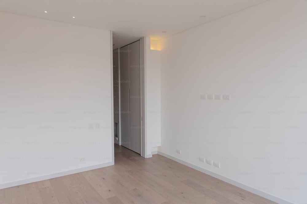una stanza vuota con pareti bianche e pavimenti in legno