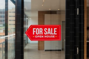 a red for sale sign in front of a glass door