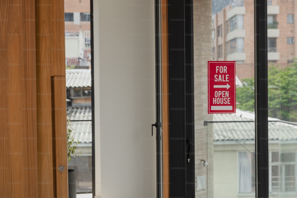 un cartello rosso in vendita su una porta a vetri