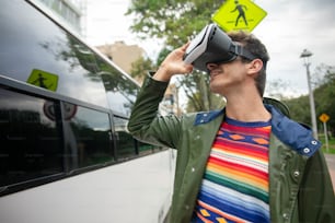 a man standing next to a bus wearing a virtual reality headset