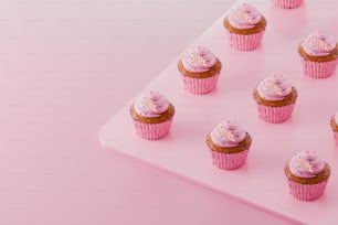 uma bandeja de cupcakes com cobertura rosa