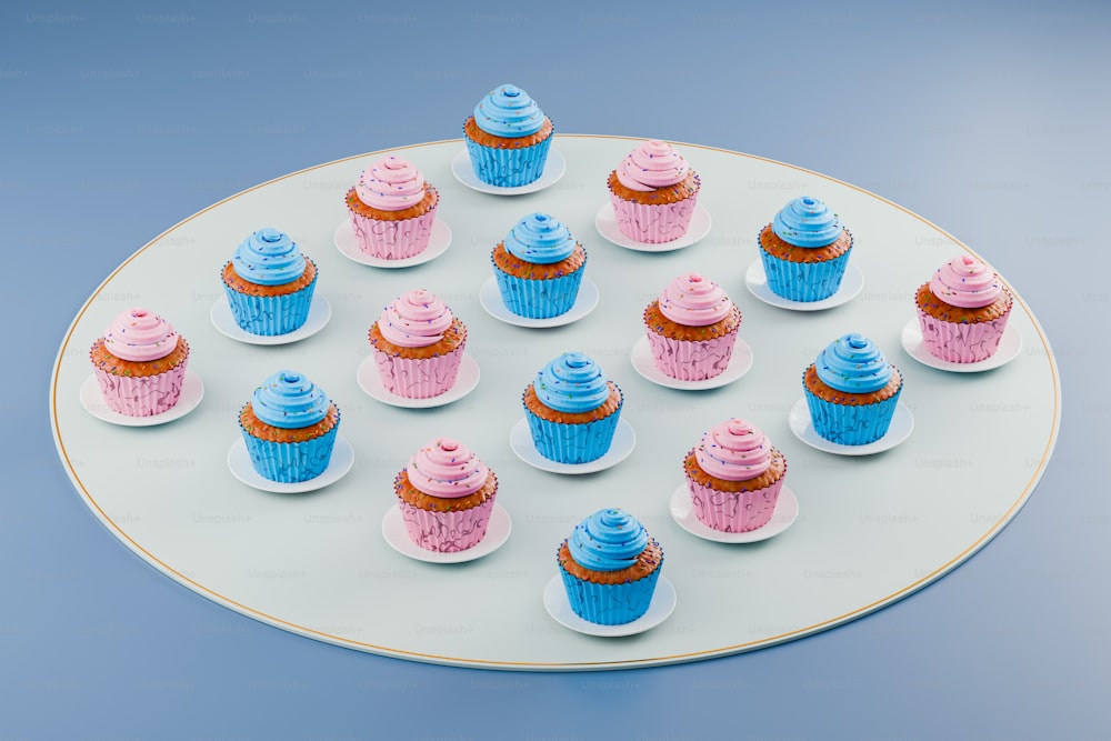 파란색과 분홍색 컵케이크를 얹은 흰색 접시