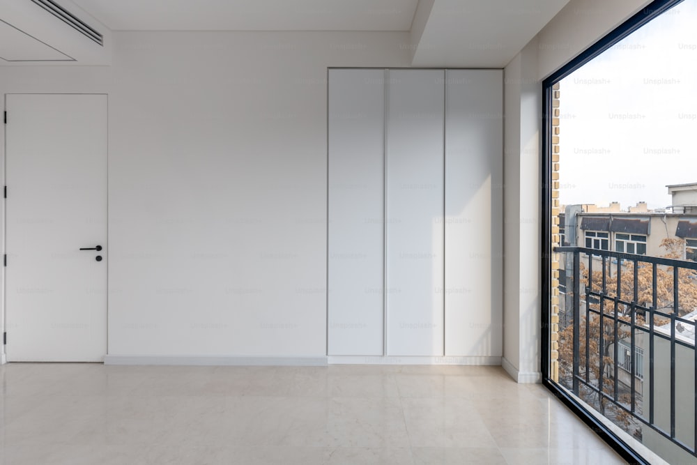 an empty room with a large window and a view of the city