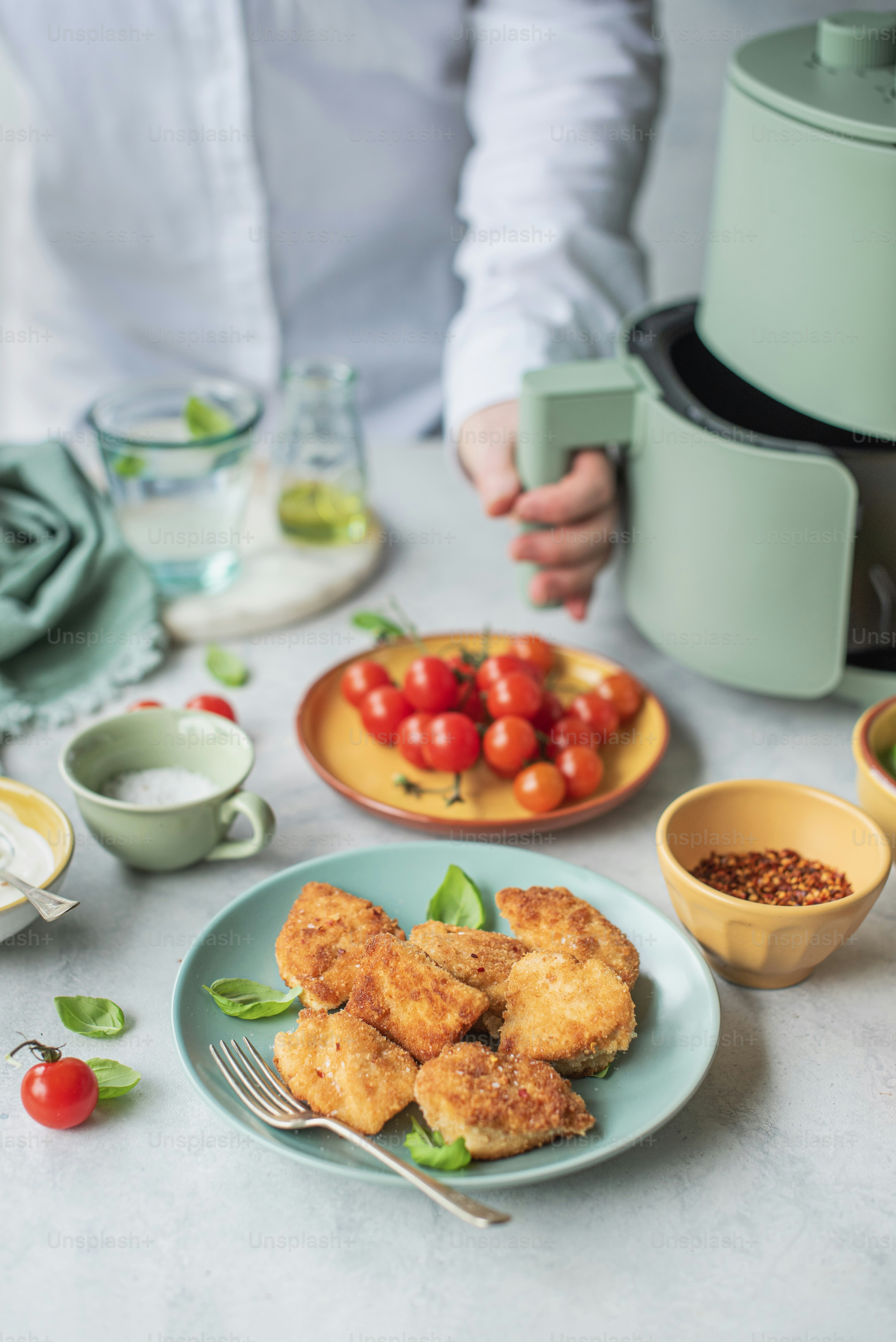 un tavolo con un piatto di cibo e una ciotola di pomodori