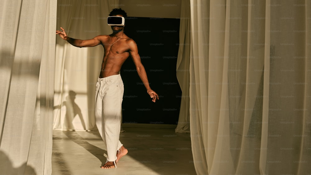 a shirtless man standing in front of a curtain