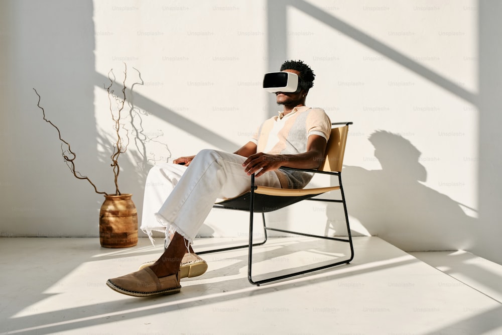 a man sitting in a chair wearing a virtual reality headset