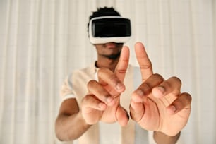 a man in a white t - shirt making a peace sign with his hands