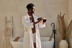 a man in a bathrobe standing in a bathroom
