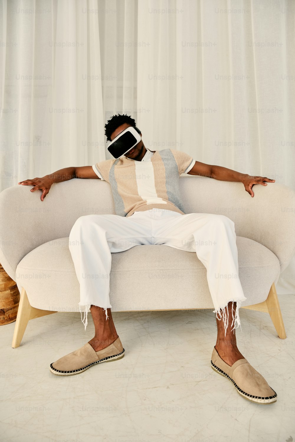 a man sitting on a couch wearing a blindfold