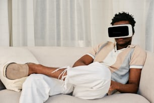 Ein Mann sitzt auf einer Couch und trägt ein virtuelles Headset