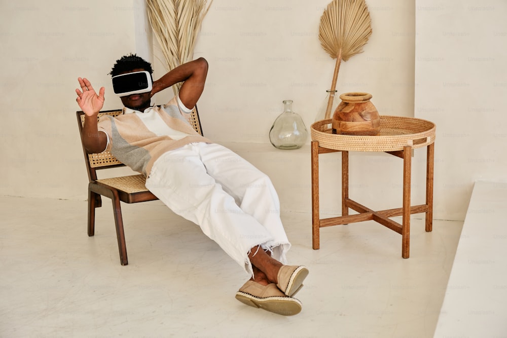 Ein Mann sitzt auf einem Stuhl mit einem Virtual-Reality-Headset