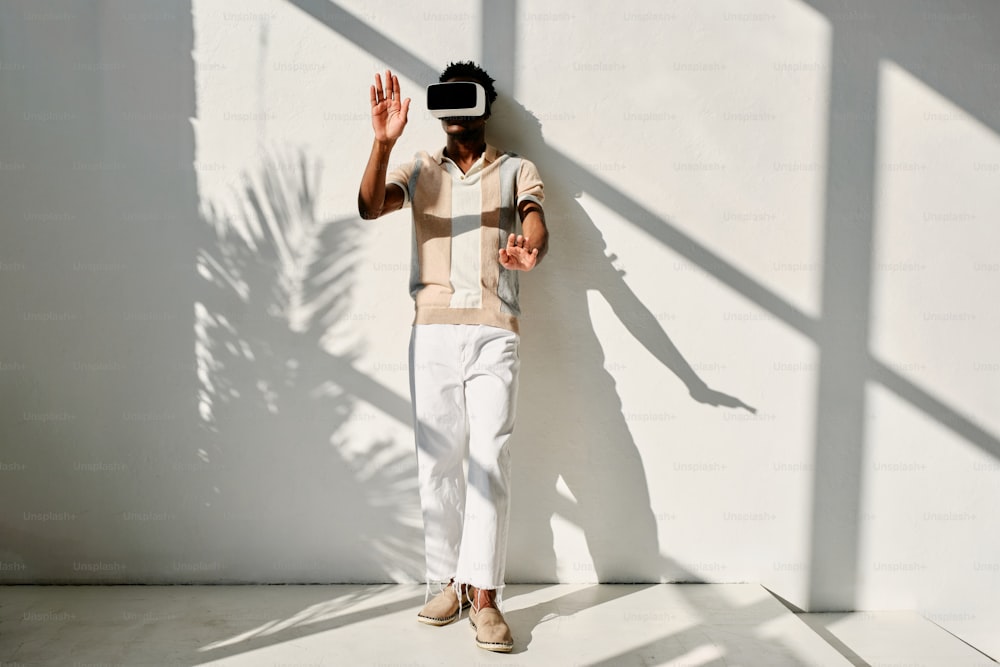 a man standing in front of a wall wearing a virtual reality headset