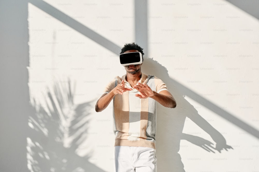 a man standing in front of a white wall wearing a blindfold
