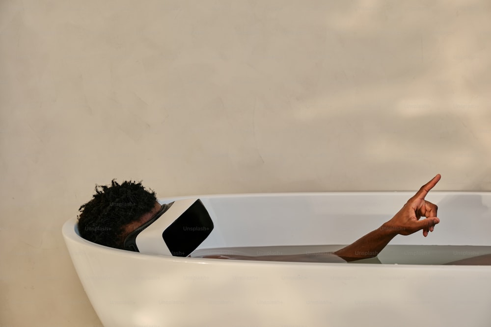 a woman in a bathtub with her hand in the water