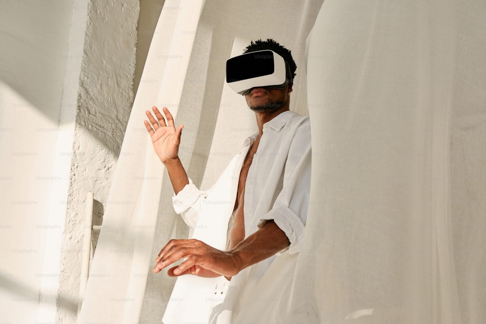 a man in a white shirt is wearing a virtual reality headset