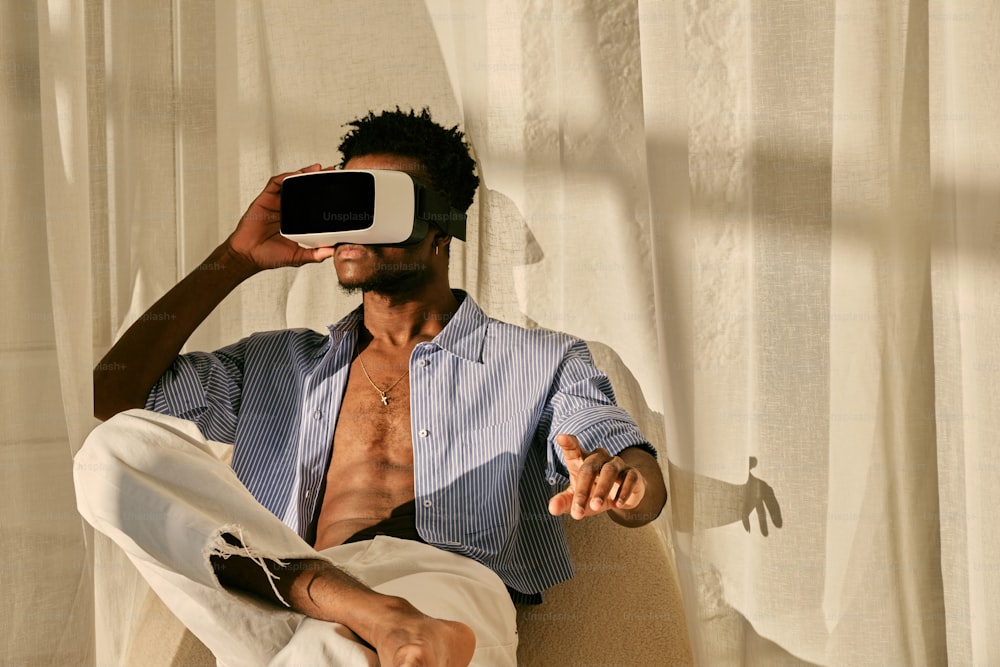 a man sitting in a chair holding a cell phone up to his face