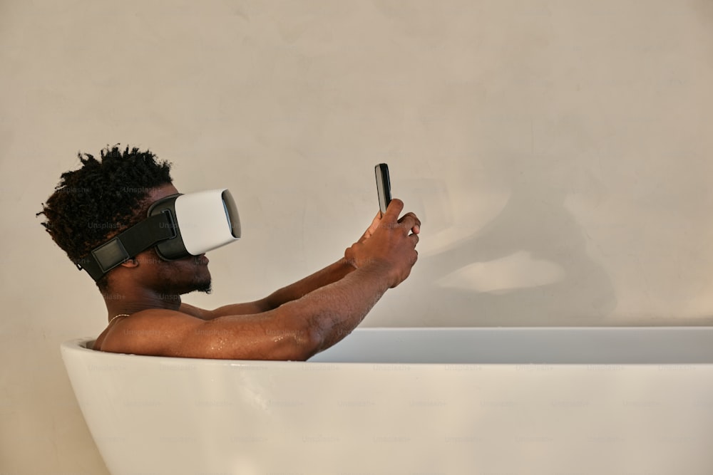 un homme dans une baignoire portant une paire de lunettes virtuelles