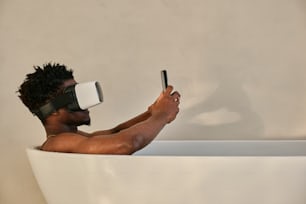 un homme dans une baignoire portant une paire de lunettes virtuelles