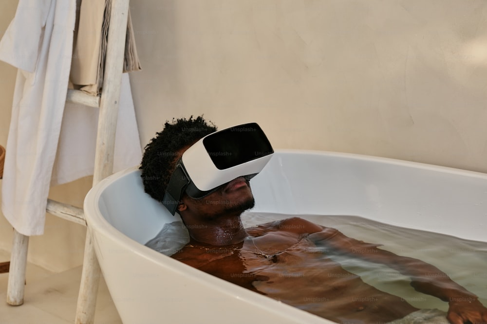 Un hombre en una bañera con un casco de realidad virtual