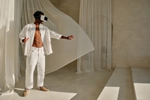 Ein Mann in weißem Hemd und weißer Hose steht vor einem Vorhang